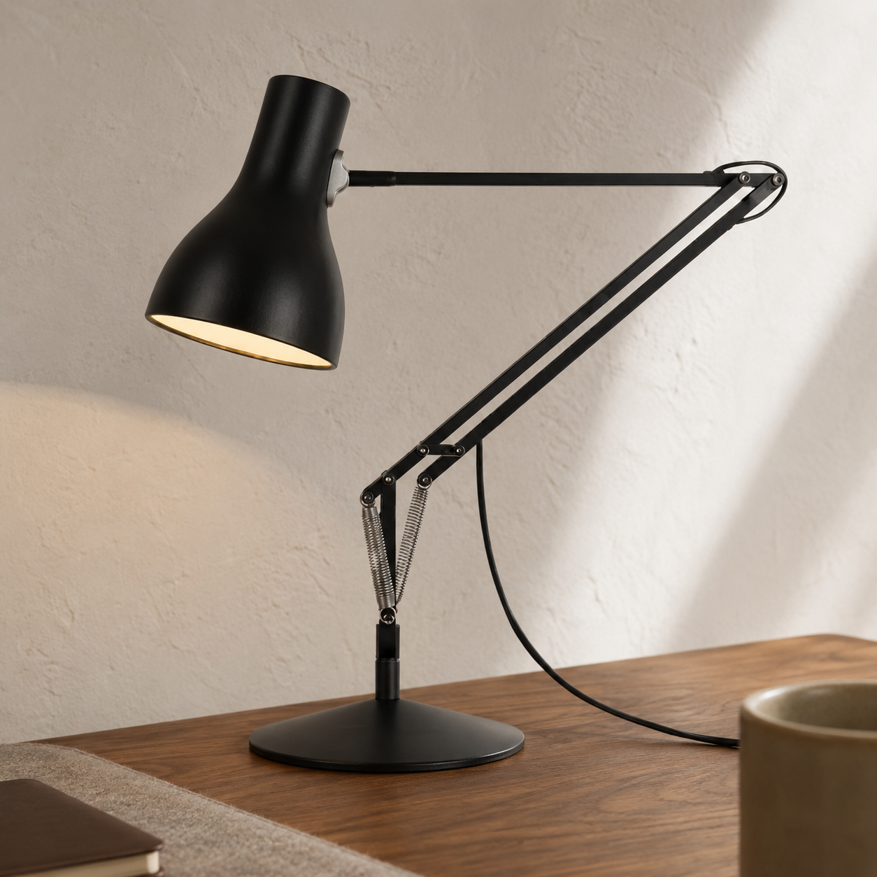 Anglepoise Type 75 Mini Desk Lamp with adjustable counterbalanced arm on a warm walnut desk