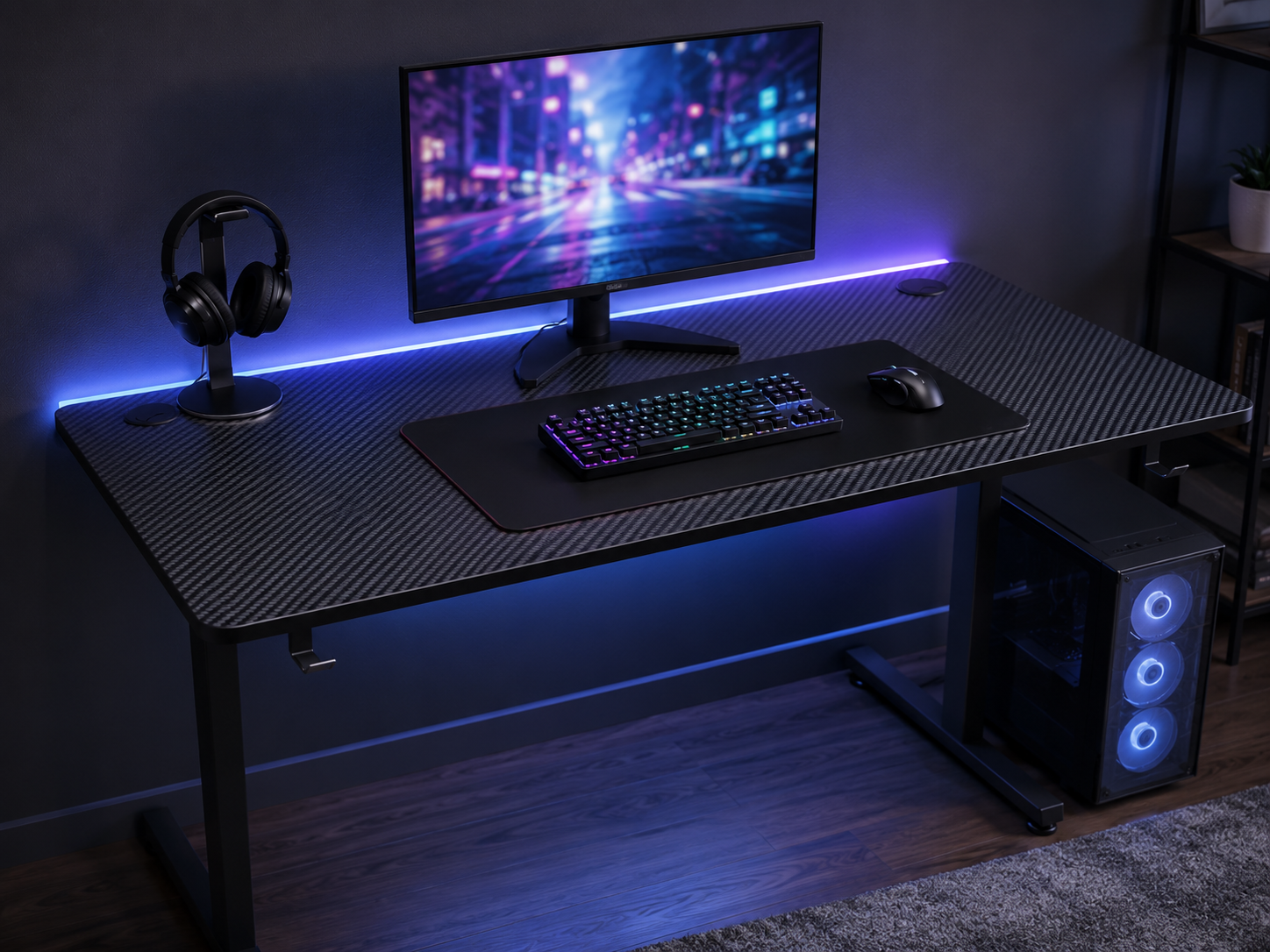 A clean budget gaming desk setup with a black gaming desk, monitor, keyboard, mouse, and subtle RGB strip glowing against a dark wall
