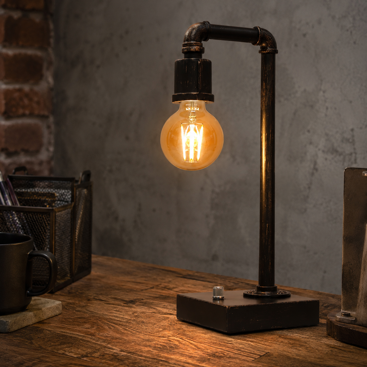 Industrial steampunk table lamp with exposed Edison bulb, metal pipe body, and USB charging port on a desk