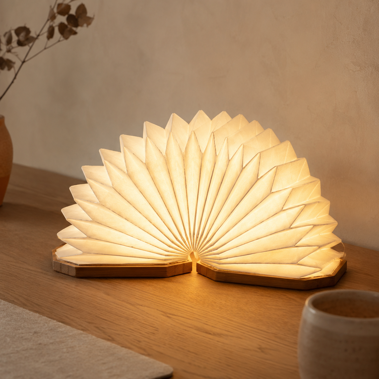 Uniwolk paper lantern desk lamp with a bamboo base and rice-paper shade glowing warmly on a light oak desk