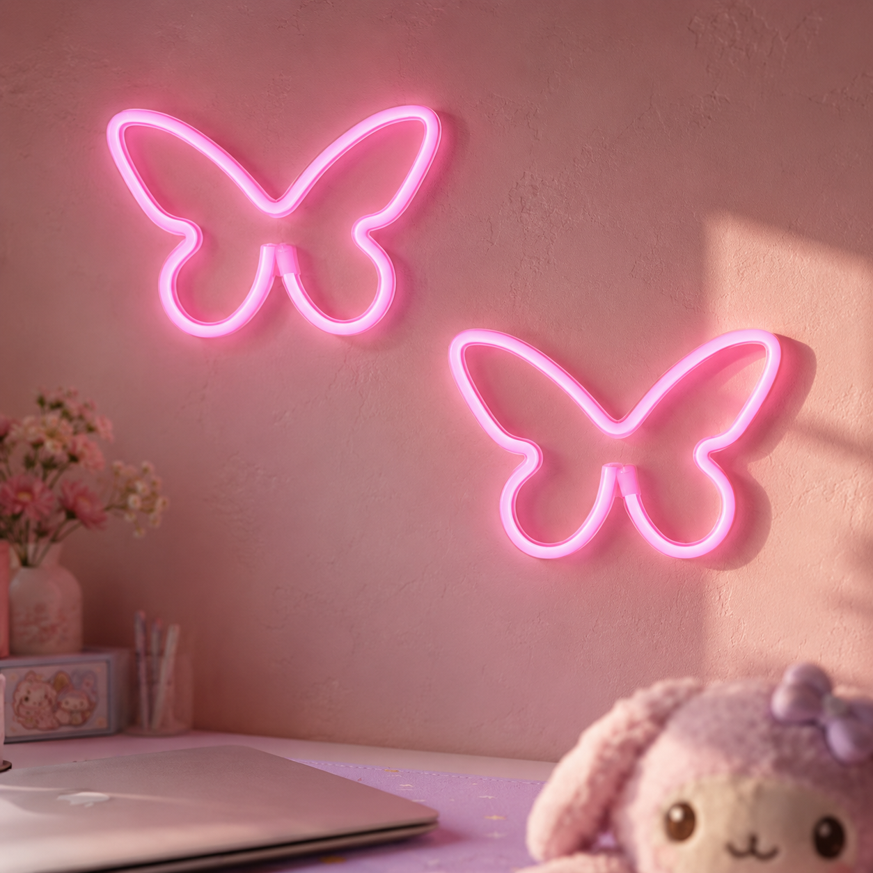 Pair of pink butterfly-shaped LED neon signs mounted on a soft pastel wall above a kawaii desk