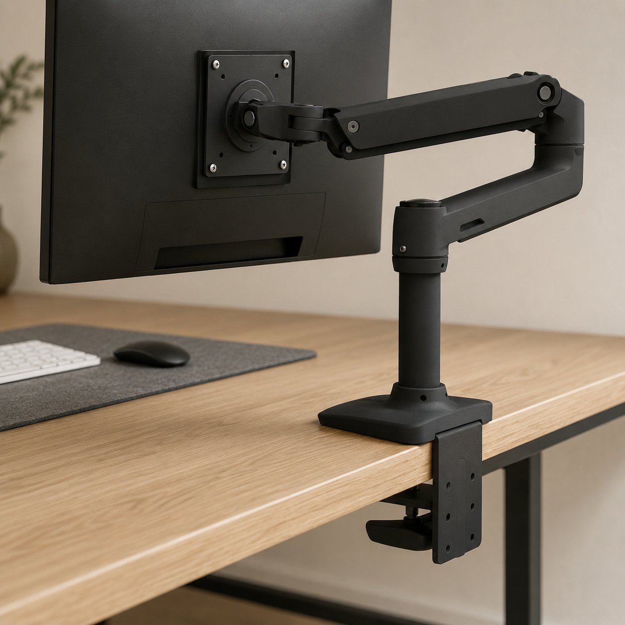 Ergotron LX Monitor Arm with desk clamp holding a 27-inch monitor suspended above a white oak desk surface