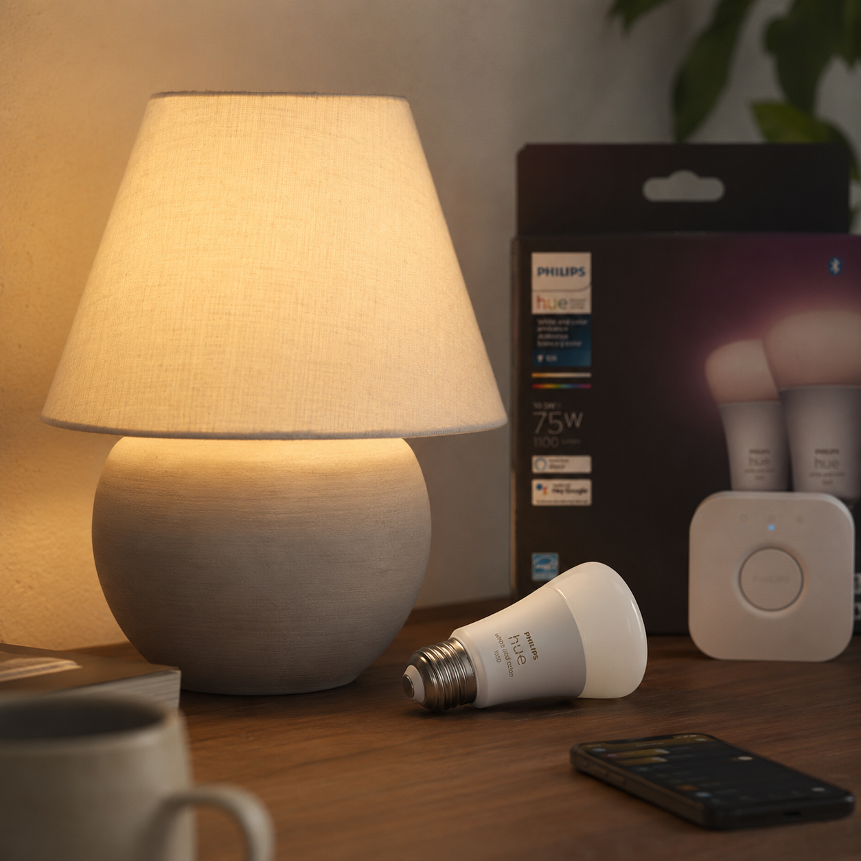 Philips Hue White Ambiance bulbs and starter kit with a warm-glowing bulb installed in a table lamp